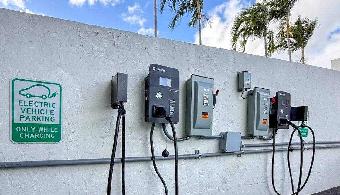 An image depicting a row of EV chargers powered by SWTCH, mounted to the wall of a parking facility at Porta Bella in Boca Raton.