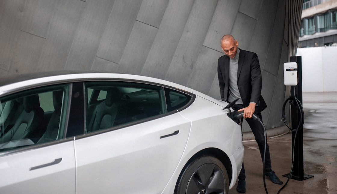 A man plugging his car in to be charged.
